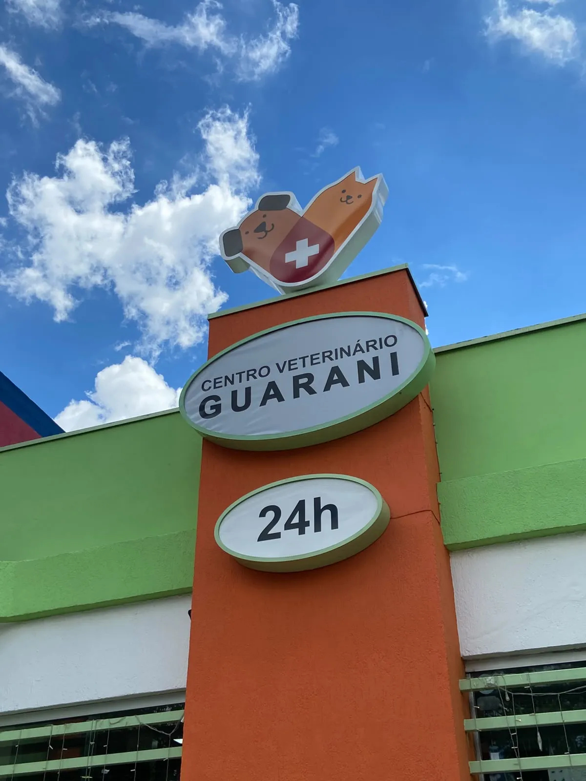Totem laranja da fachada do Centro Veterinário Guarani com o letreiro 24h